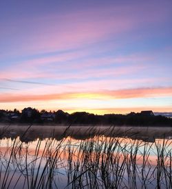 Scenic view of lake against romantic sky at sunset