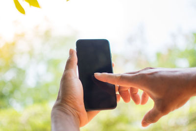 Close-up of cropped hands using smart phone