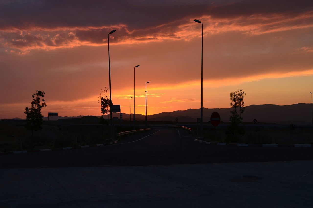 sunset, orange color, sky, cloud - sky, silhouette, street light, the way forward, transportation, scenics, beauty in nature, road, dramatic sky, tranquility, cloud, nature, tranquil scene, idyllic, cloudy, outdoors, no people