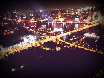 Illuminated cityscape against sky at night