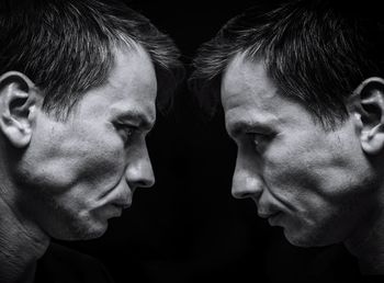 Close-up portrait of young man against black background