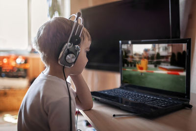 A boy watching hot news about closed sport ground and playground via internet on the laptop screen