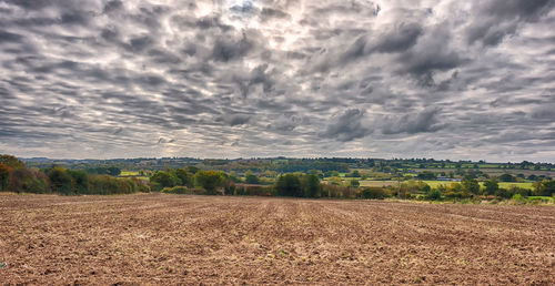 Scenic view of field against cloudy sky