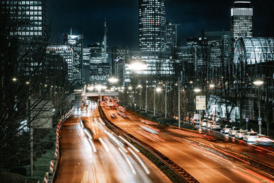 High angle view of light trails on the road between the skyscrapers at night