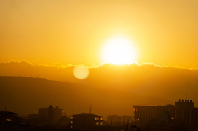 Silhouette buildings against sky during sunset