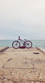 Bicycle on beach against sky