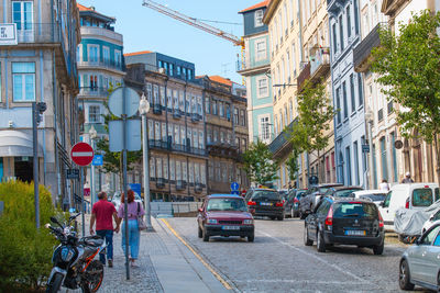 Vehicles on road by buildings in city