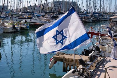 The israeli flag against the background of the yachts of the herzliya marina.