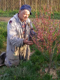 Full length of man holding flower in field