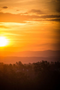 Scenic view of silhouette landscape against orange sky