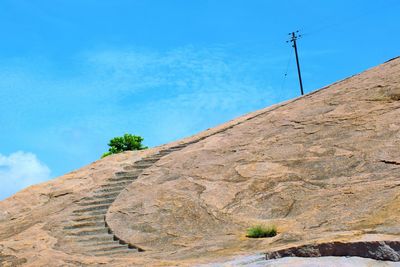 Low angle view of mountain against blue sky