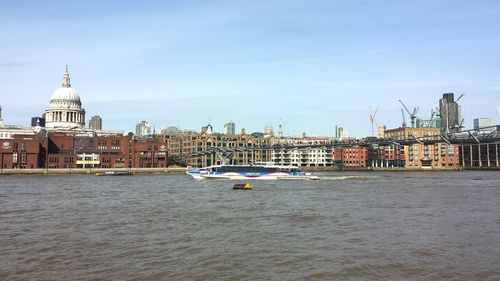 Boats in sea with city in background