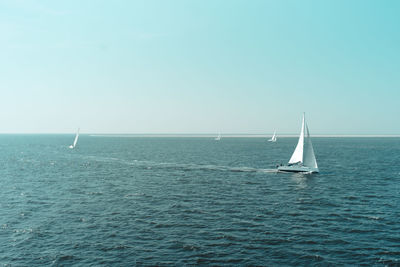 Sailboat sailing in sea against sky