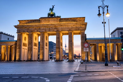 The brandenburg gate with the tv tower in the back at dawn, seen in berlin, germany