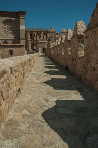 Pathway over stone wall with battlement around the town and side view of cathedral in avila, spain.