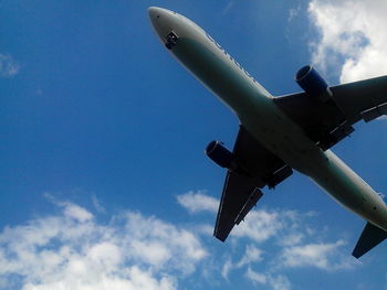 Low angle view of airplane flying against sky