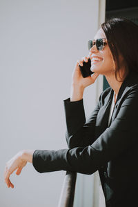 Smiling young businesswoman talking on mobile phone