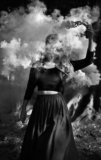 Woman holding distress flare while standing on ground