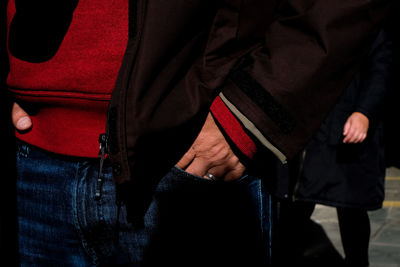 Midsection of man standing against wall