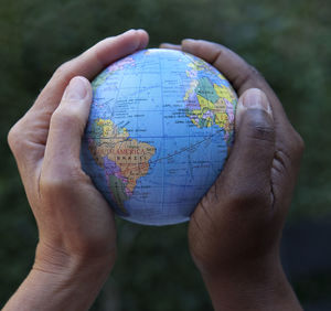 Cropped hands holding globe