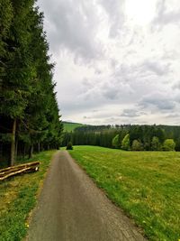 Road amidst green landscape against sky