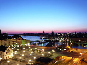 Illuminated city against clear sky at night