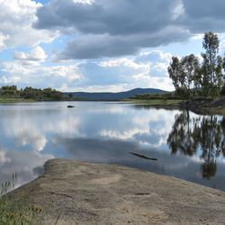 Scenic view of calm lake against cloudy sky