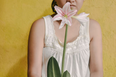 Midsection of woman holding white flower