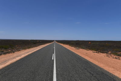 Road passing through land against sky