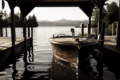 Moored boat in calm lake against clear sky