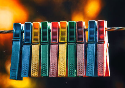 Close-up of colorful clothespins attached on clothesline