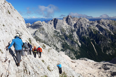 Rear view of people on mountain against sky