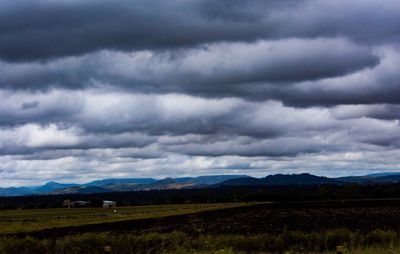 Scenic view of field against cloudy sky