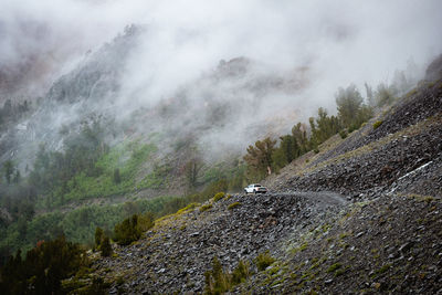 Adventure truck on the side of a foggy mountain trail.