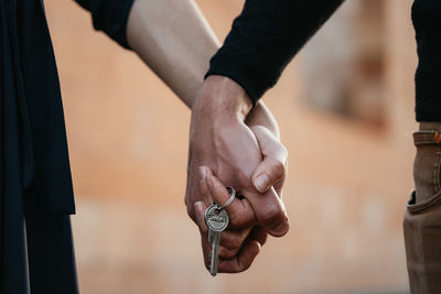 Close-up of man holding hands against blurred background