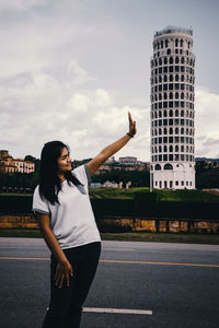 Full length of woman standing against sky in city