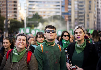 Portrait of friends against buildings in city