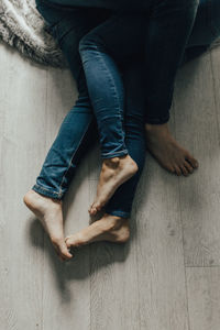 Low section of couple hugging on hardwood floor