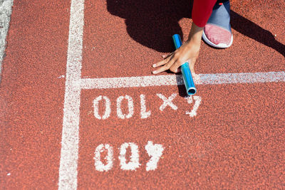 Low section of woman holding equipment on running track