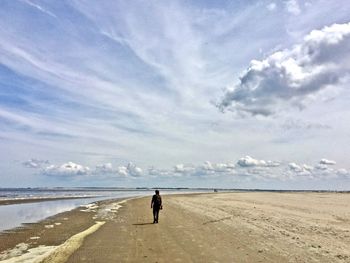 Rear view of man walking on beach