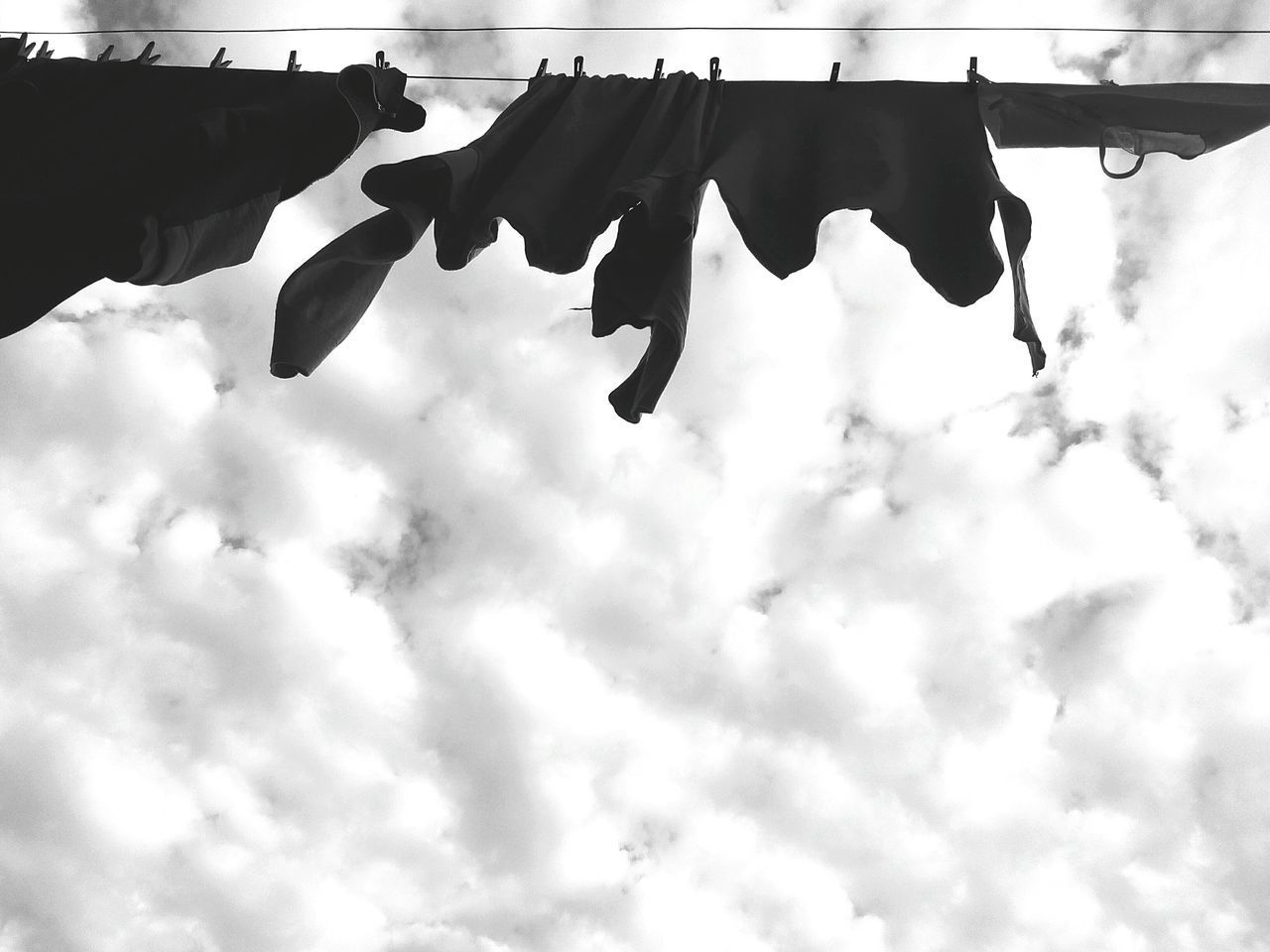 LOW ANGLE VIEW OF CLOTHESLINE HANGING AGAINST SKY