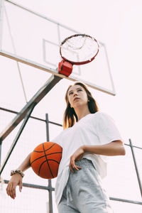 Portrait of a thoughtful girl basketball player with a ball in her hands. basketball, sports