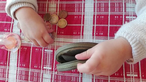 Low section of girl holding coin purse