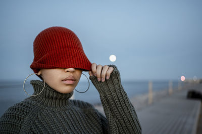 Portrait of smiling woman standing against sky during winter