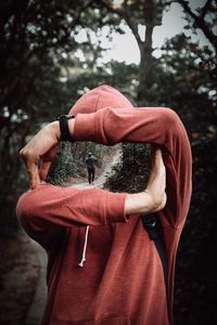 Rear view of man standing against trees