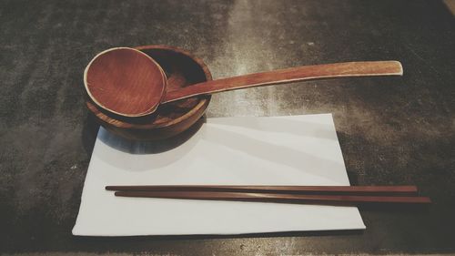 High angle view of chopsticks and wooden spoon on table