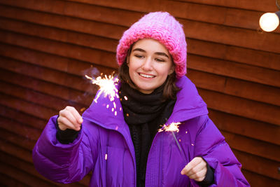 Portrait of young woman in puff with sparklers in her hands smiling cute
