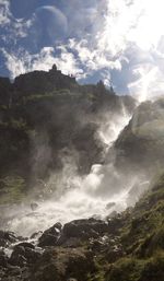 Scenic view of waterfall against sky
