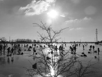 Silhouette people on beach against sky