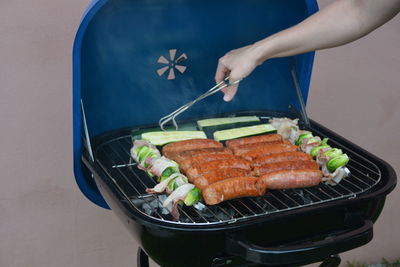 High angle view of person preparing food on barbecue grill